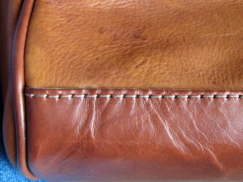 Fat wrinkled leather used for the bottom of the bag with possible tick/flea marks present on the deerskin above